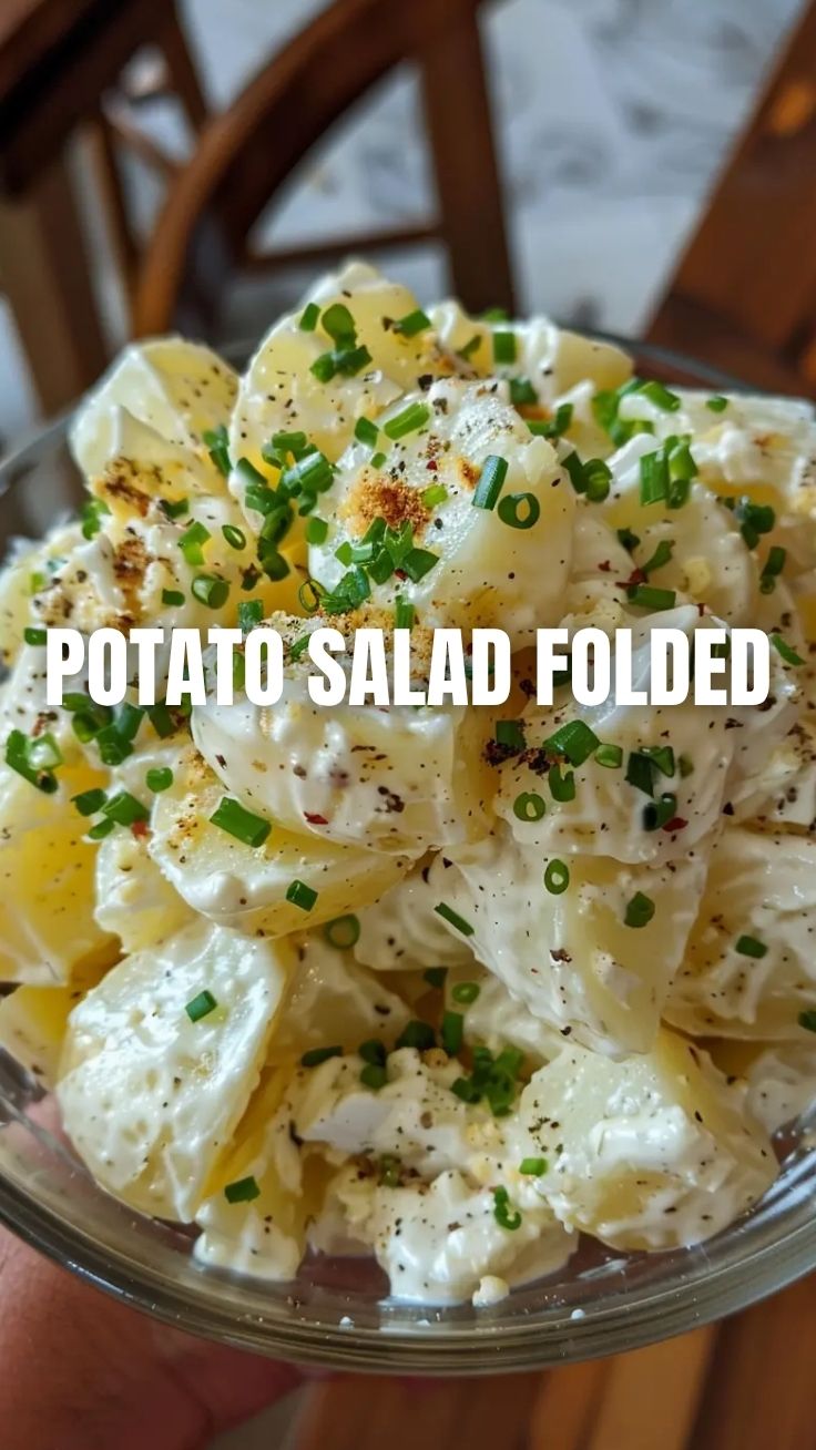 A bowl of creamy potato salad with herbs and seasoning