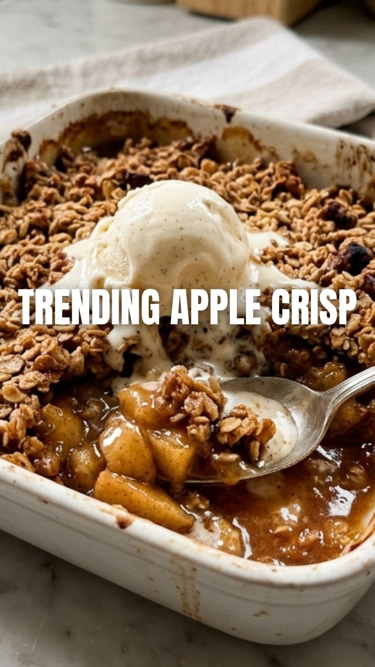 A freshly baked apple crisp with a golden-brown topping, served in a rustic bowl.