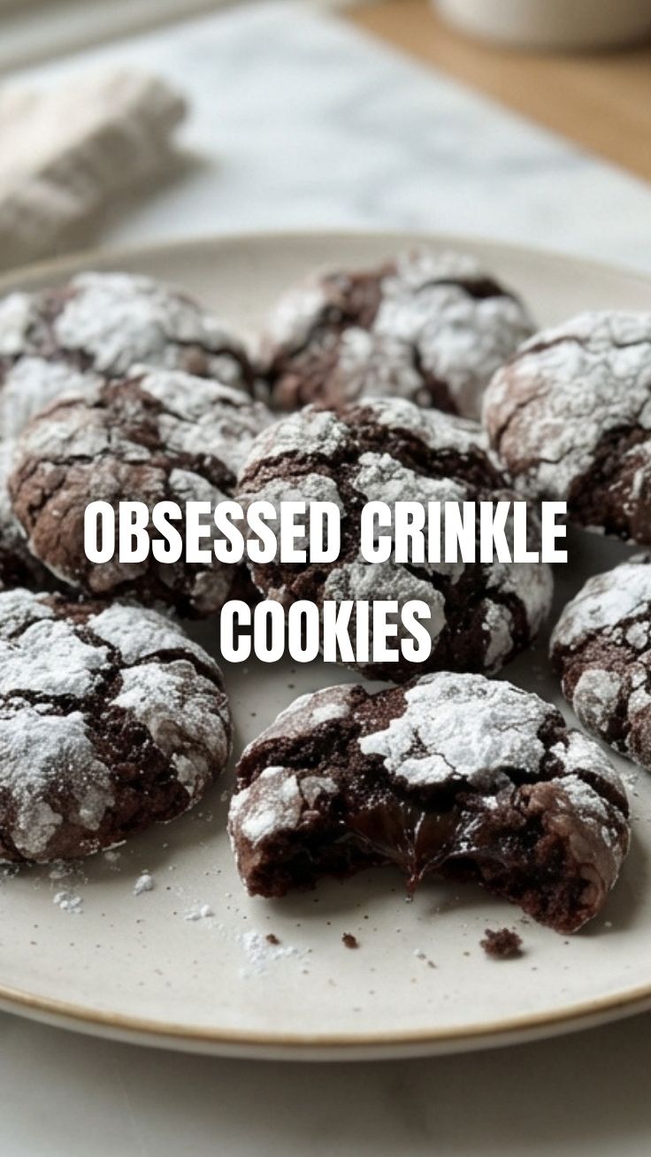 A close-up of several chocolate crinkle cookies dusted with powdered sugar