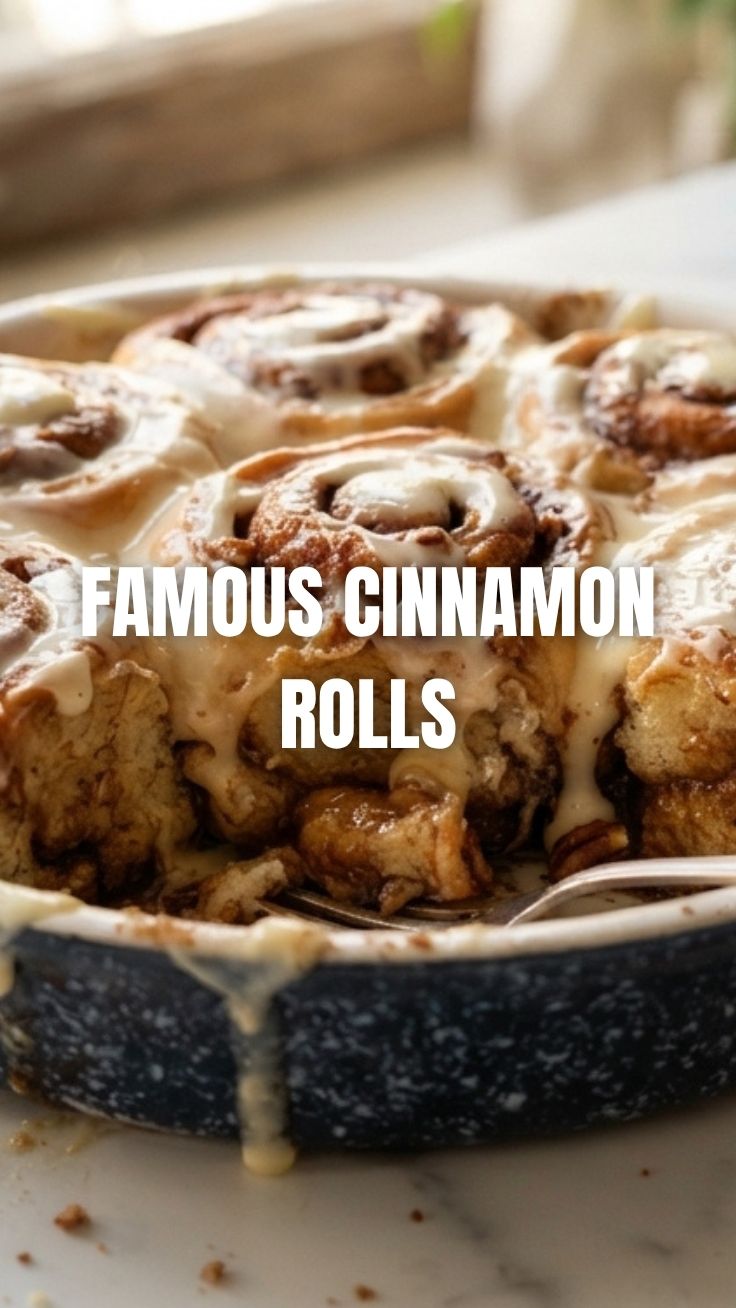 Freshly baked cinnamon rolls with white icing in a pan