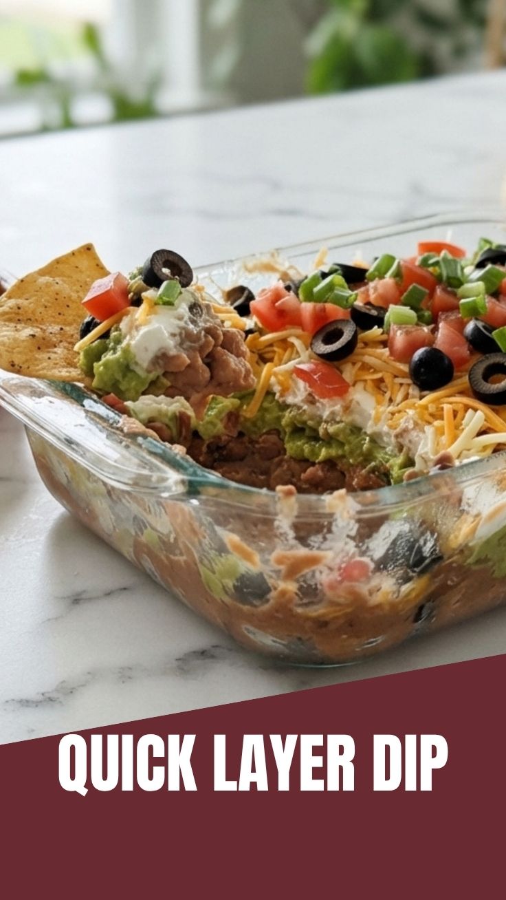 A fresh seven layer dip with distinct colorful layers in a clear bowl